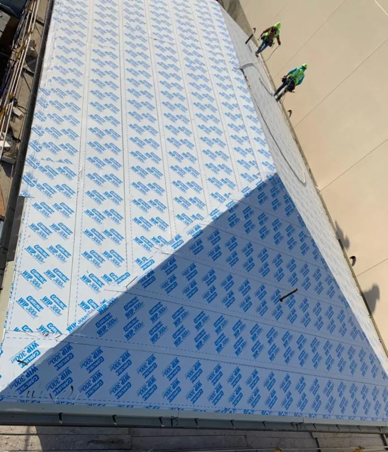 Professional roofers installing underlayment on a metal roof in Salt Lake City